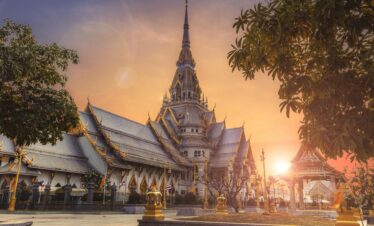 Scenic view of Wat Sothonwararam Temple during sunset in Thailand, capturing its beautiful architecture.
