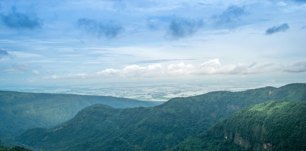 Stunning aerial landscape of lush green mountains and expansive sky, capturing natural beauty and serenity.