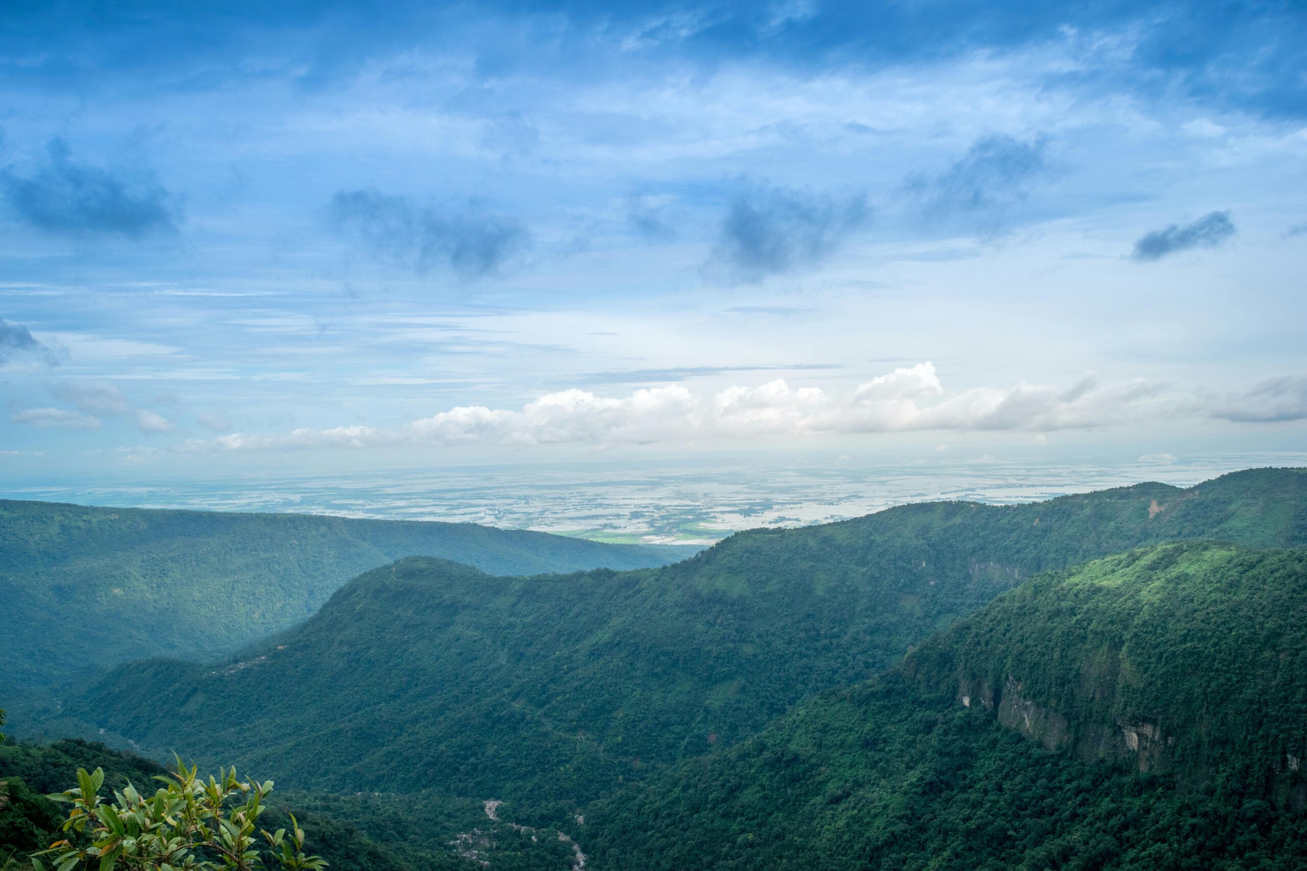 Stunning aerial landscape of lush green mountains and expansive sky, capturing natural beauty and serenity.
